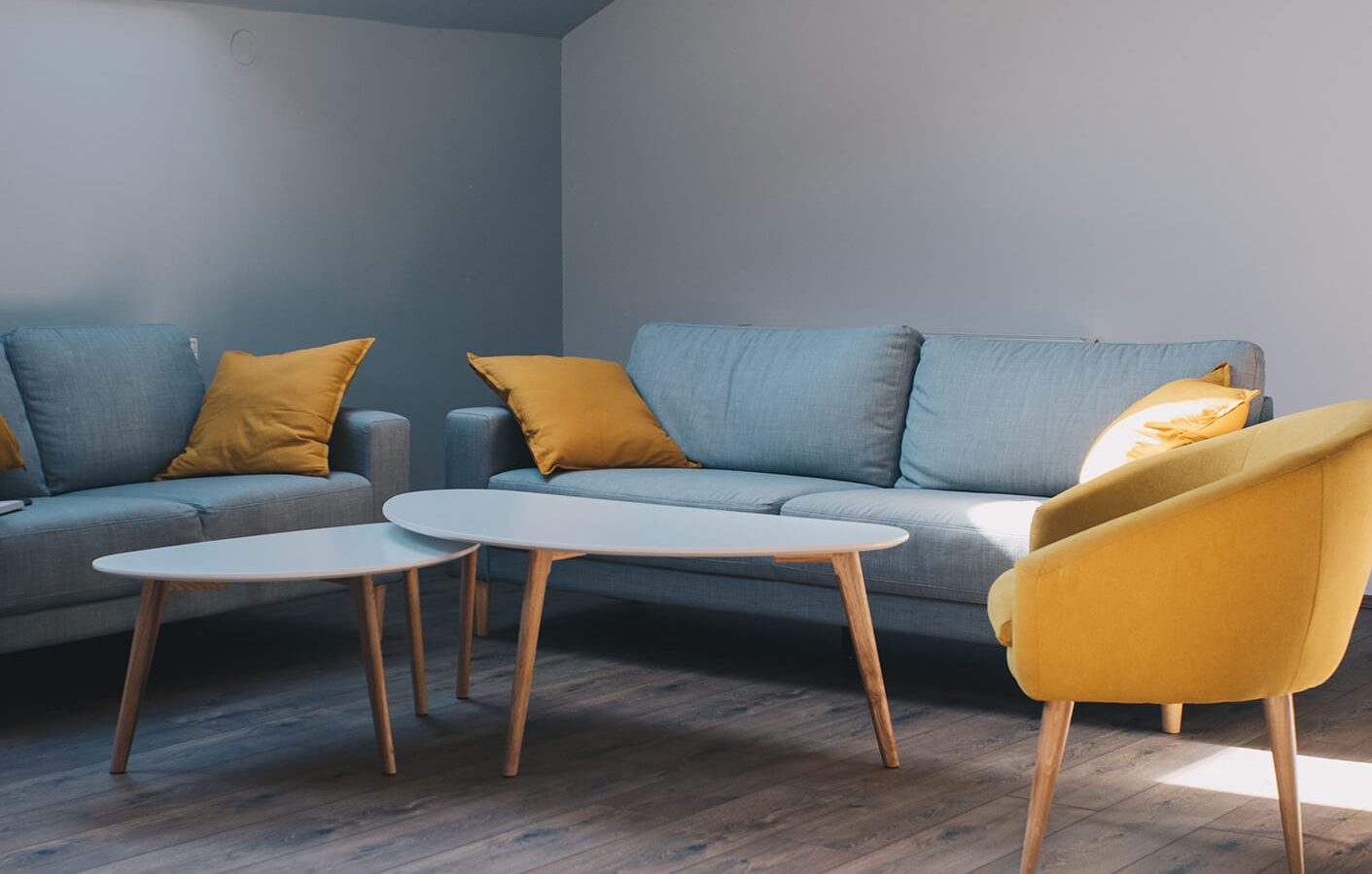 a living room with yellow and blue furniture at The Discovery Park Life Apartments